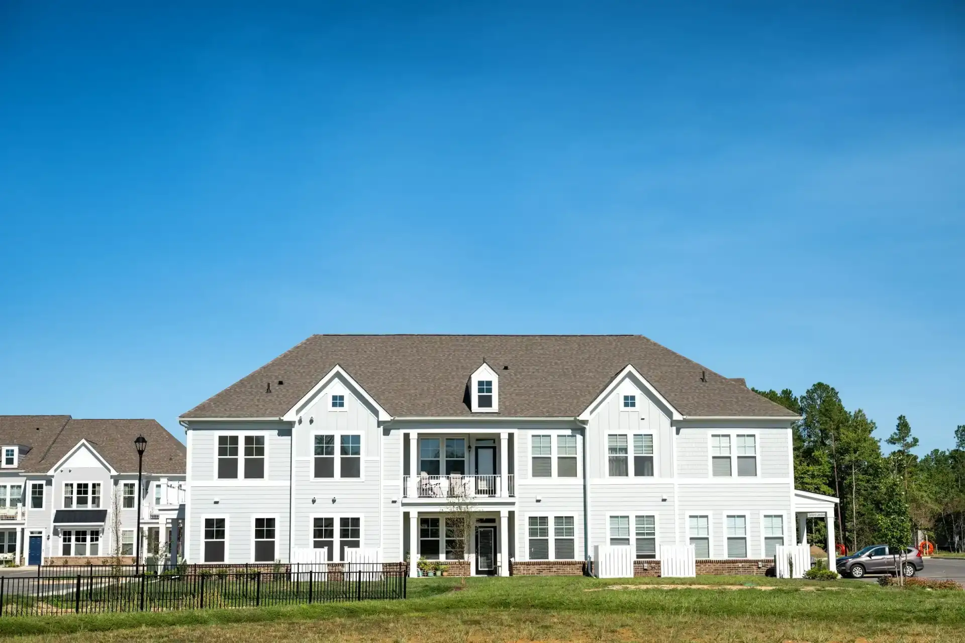 Large white multi-family residence on a lawn